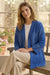 Woman wearing a navy-colored embroidered kimono-style jacket with open front and side pockets from Johnny Was
