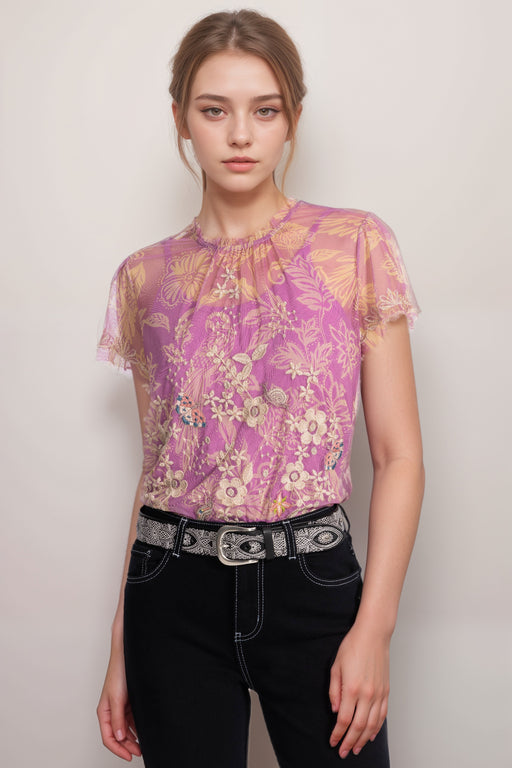 Woman wearing a pink mesh top with floral print, embroidery, and inner cami top from Johnny Was