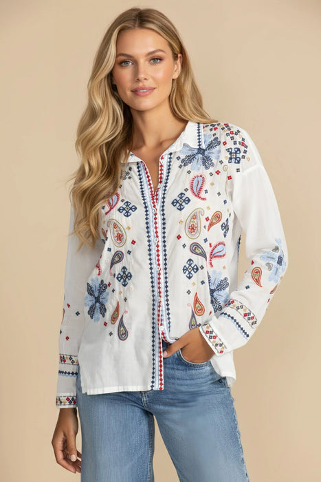 Woman wearing a white button down shirt with colorful embroideries and long sleeves from Johnny Was