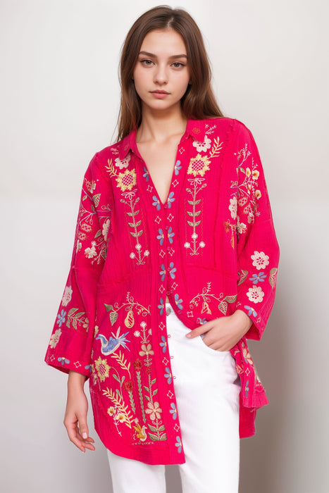 Woman wearing a bright pink embroidered tunic top with 3/4 sleeves from Johnny Was