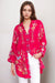 Woman wearing a bright pink embroidered tunic top with 3/4 sleeves from Johnny Was