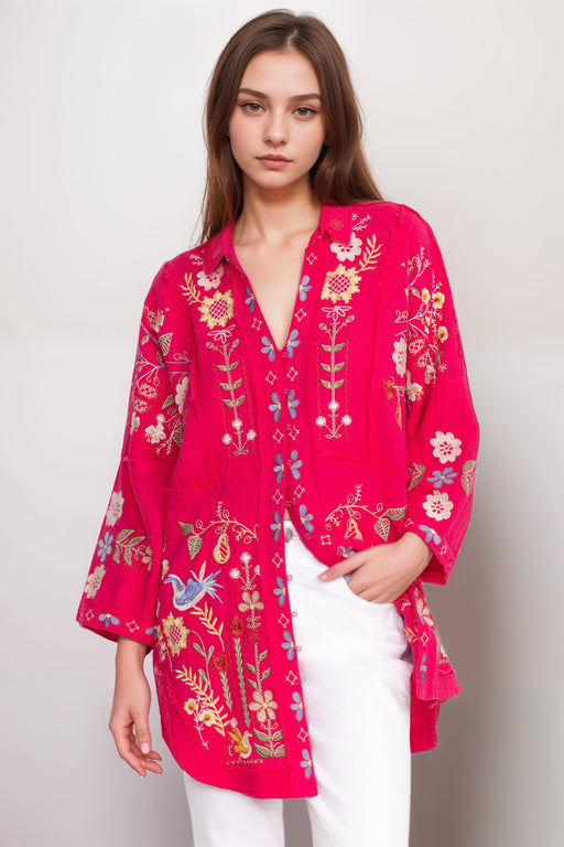 Woman wearing a bright pink embroidered tunic top with 3/4 sleeves from Johnny Was