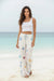Woman wearing a white embroidered wide leg pant with drawstring elastic waistband from Johnny Was