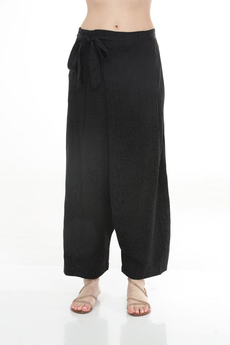 Woman wearing a black animal printed wide leg pants with elastic waistband from Johnny Was