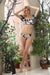 Woman wearing Johnny Was Black Palmas Bikini Set with puff sleeve top and tropical print bottom