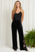 Woman wearing a black embroidered wide leg velvet pants from Johnny Was