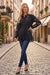 Woman in a black embroidered shirt with lace hem trim and long sleeves from Johnny Was