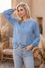 Woman wearing a blue tunic top with tonal embroidery and bishop sleeves from Johnny Was