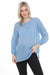 Woman wearing a blue tunic top with tonal embroidery and bishop sleeves from Johnny Was