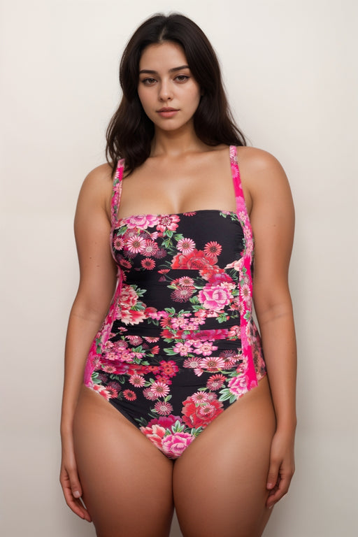 Woman wearing a floral one-piece swimsuit with ruching at the front and adjustable straps from Johnny Was