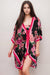 Woman wearing a floral kimono-style cover up with pink stripe edges and front tie from Johnny Was