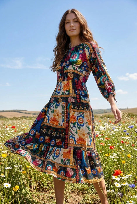 Woman wearing a colorful floral patchwork patterned midi dress with 3/4 sleeves from Johnny Was