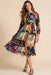 Woman wearing a colorful floral patchwork patterned midi dress with 3/4 sleeves from Johnny Was