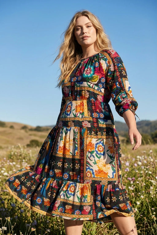 Woman wearing a colorful floral patchwork patterned midi dress from Johnny Was