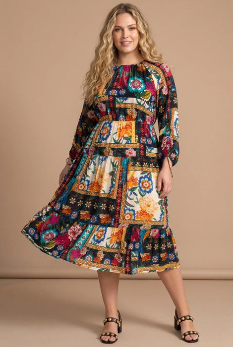 Woman wearing a colorful floral patchwork patterned midi dress from Johnny Was