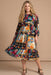 Woman wearing a colorful floral patchwork patterned midi dress from Johnny Was