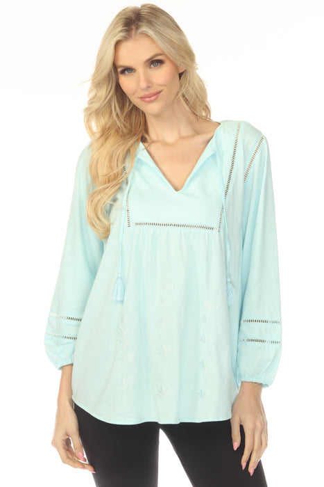 Woman wearing a light blue tunic top with ladder stitch trim and embroidered front from Johnny Was
