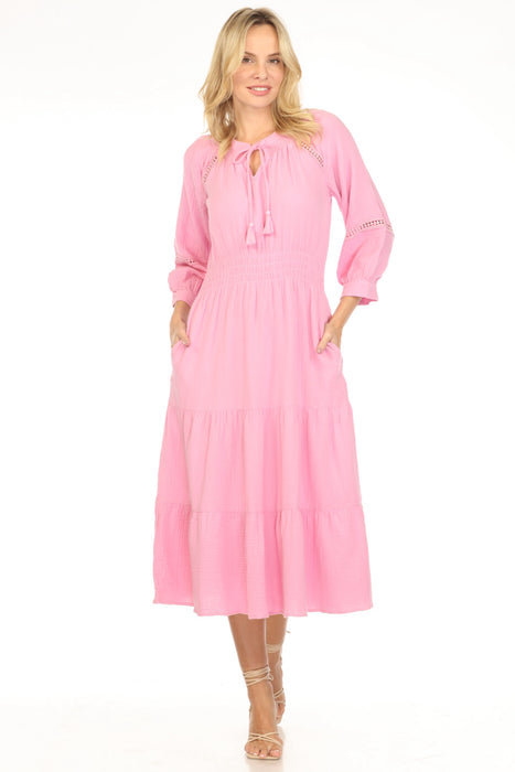 Woman wearing a pink midi dress with smocked waist and tiered skirt from Johnny Was