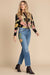 Woman wearing a blue medium wash distressed jeans with floral embroideries and straight cropped leg from Johnny Was