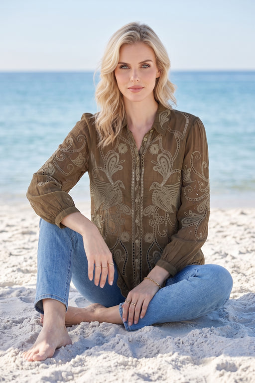 Woman wearing an olive green embroidered shirt with long sleeves and button front from Johnny Was