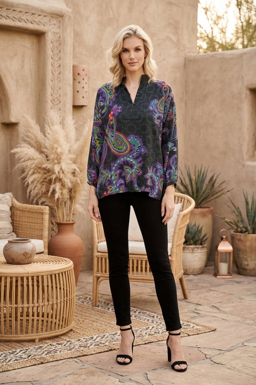 Woman wearing a colorful paisley patterned top with v-neck and puff sleeves from Johnny Was