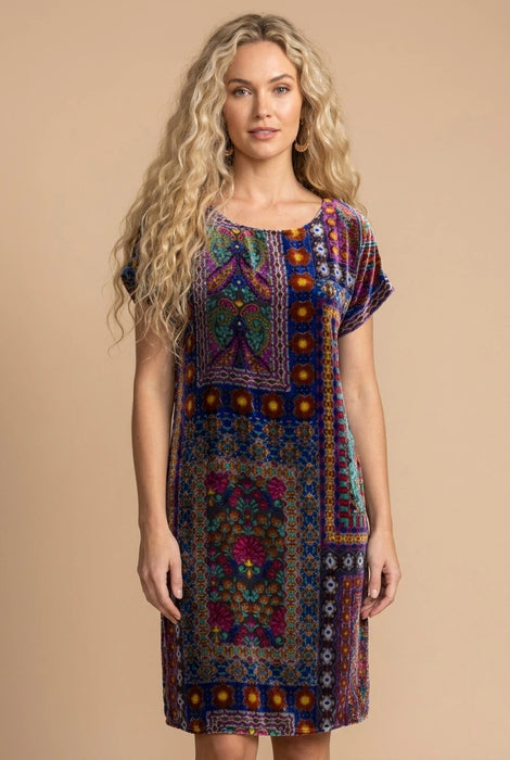 Woman wearing a colorful burnout patterned shift dress with short dolman sleeves from Johnny Was