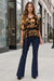 Woman wearing a gold and black patterned top with v-neck and elbow sleeves from Johnny Was