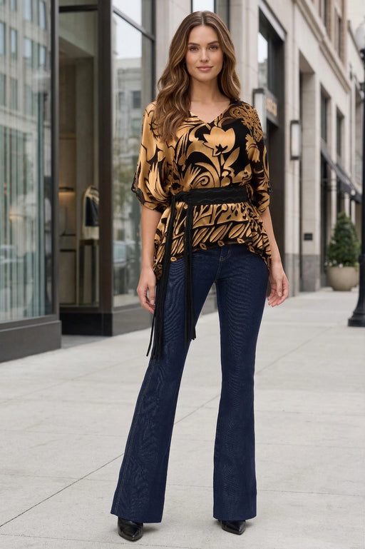 Woman wearing a gold and black patterned top with v-neck and elbow sleeves from Johnny Was