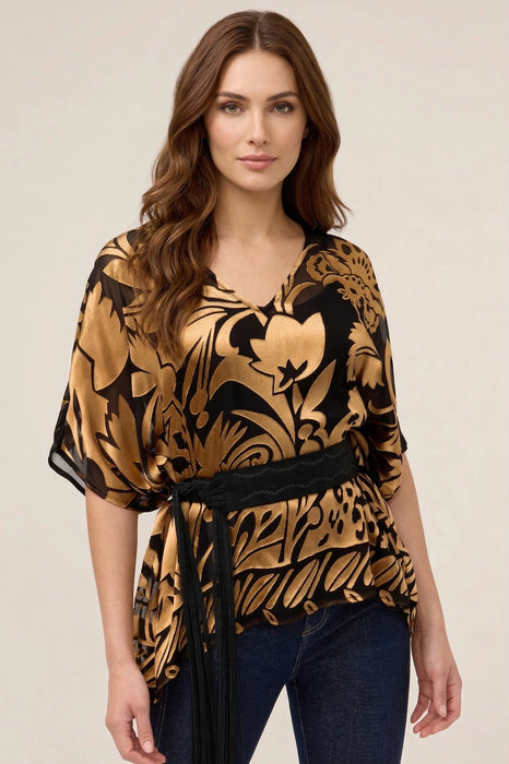 Woman wearing a gold and black patterned top with v-neck and elbow sleeves from Johnny Was