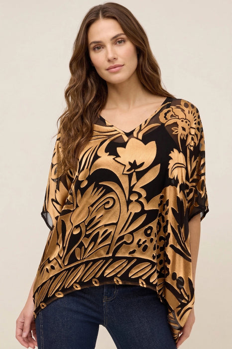 Woman wearing a gold and black patterned top with v-neck and elbow sleeves from Johnny Was