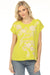 Woman wearing a yellow green floral embroidered top with crew neck and cap sleeves from Johnny Was