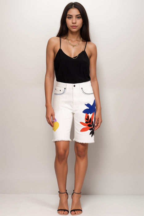 Woman wearing a white denim bermuda short with splash of color from Johnny Was