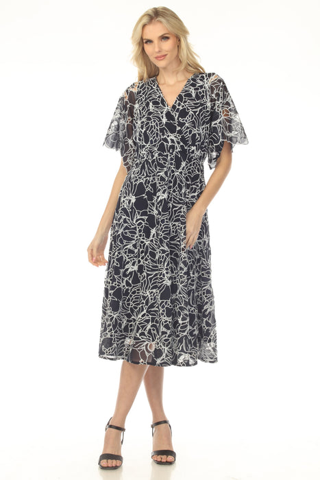 Woman wearing a navy floral-patterned midi dress from Johnny Was