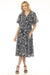 Woman wearing a navy floral-patterned midi dress from Johnny Was
