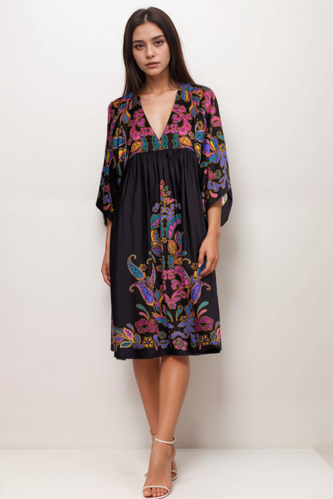 Woman wearing a black cover up dress with colorful paisley pattern and v-neck from Johnny Was