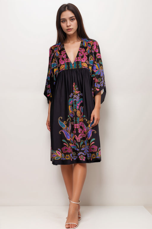 Woman wearing a black cover up dress with colorful paisley pattern and v-neck from Johnny Was