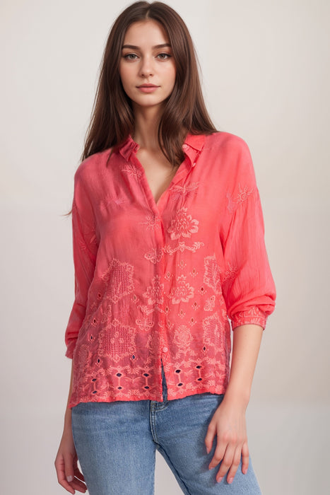 Woman wearing a coral breathable shirt with tonal embroidery and button down closure