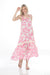 Woman wearing a pink floral and butterfly printed maxi dress with square neck and wide straps from Johnny Was