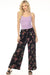 Woman wearing a black velour wide leg pant with floral and butterfly pattern from Johnny Was