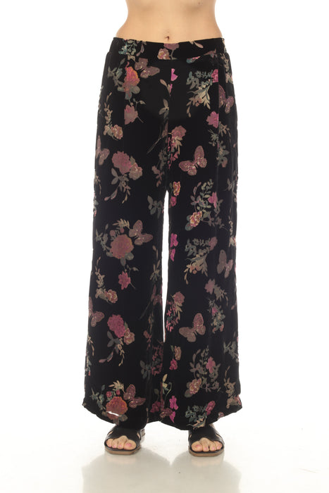 Woman wearing a black velour wide leg pant with floral and butterfly pattern from Johnny Was