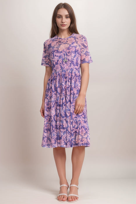 Woman wearing a mesh dress with floral scroll pattern and tiered skirt from Johnny Was