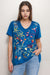 Woman wearing a blue t-shirt with colorful embroideries and v-neck from Johnny Was