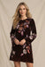 Woman wearing an animal-patterned velvet dress with floral embroideries and long kimono sleeves from Johnny Was
