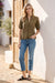 Woman wearing a green button front top with intricate tonal embroidery and short sleeves from Johnny Was