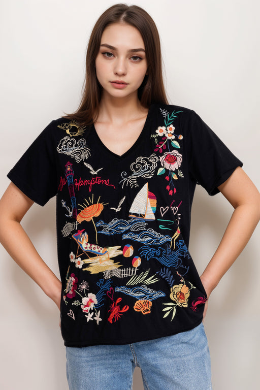 Woman wearing a black embroidered tee with v-neck and short sleeves from Johnny Was