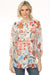 Woman wearing a colorful floral-printed silk tunic top with button front and 3/4 sleeves from Johnny Was