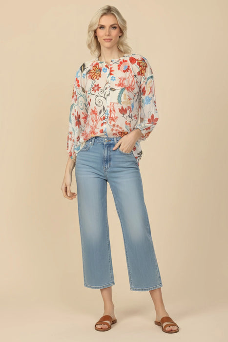 Woman wearing a colorful floral-printed silk tunic top with button front and 3/4 sleeves from Johnny Was