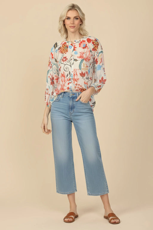 Woman wearing a colorful floral-printed silk tunic top with button front and 3/4 sleeves from Johnny Was