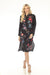 Woman wearing a black floral embroidered silk shirt dress with long sleeves and side slit from Johnny Was