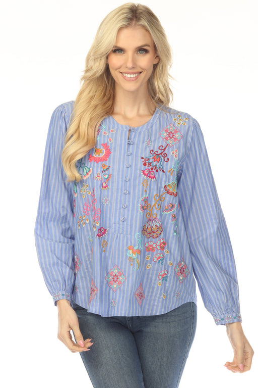 Woman wearing a blue striped blouse with colorful embroideries and henley neckline from Johnny Was